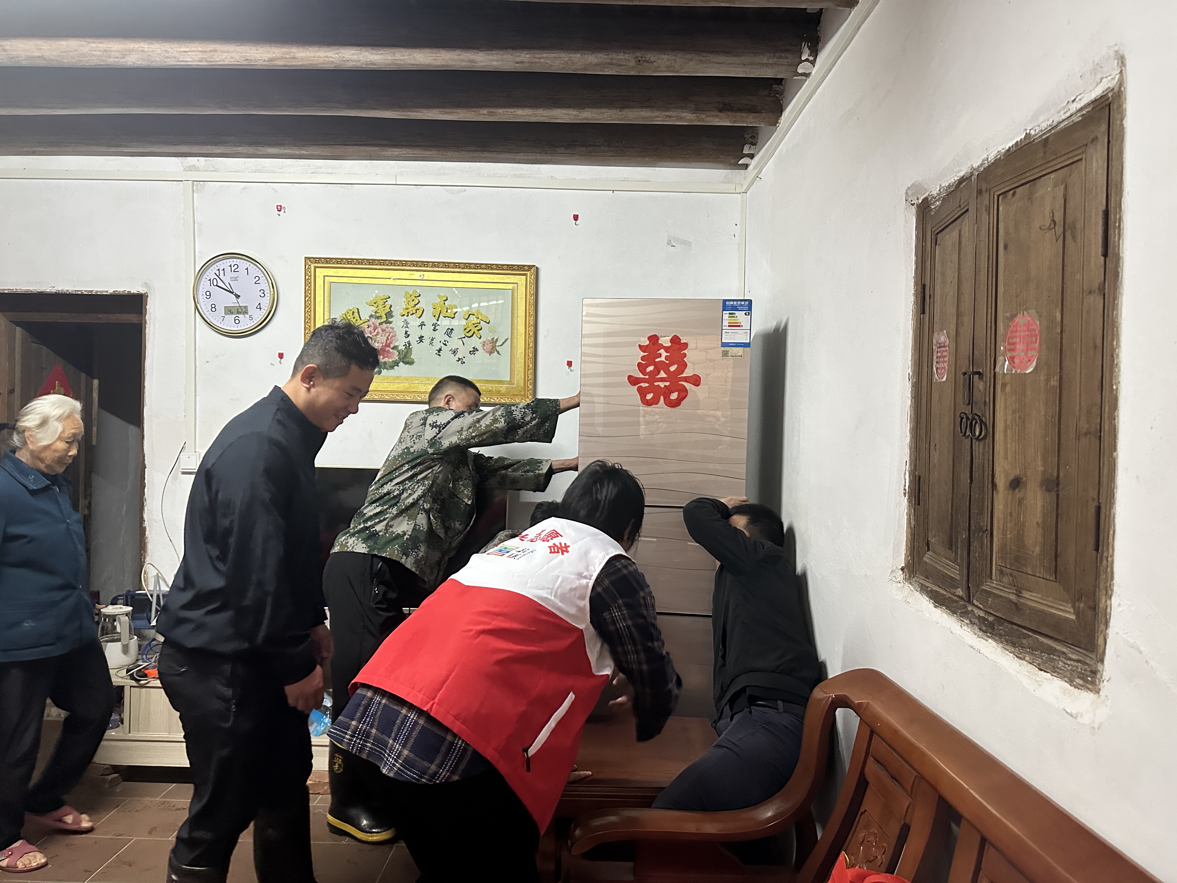 图为：罗坝镇人大代表与镇、村干部通力合作，帮助居住在地势低洼地带的村民垫高家电，确保村民生命财产安全。.jpg